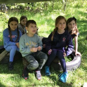 Year 4 children sat on tyres outside in a forest