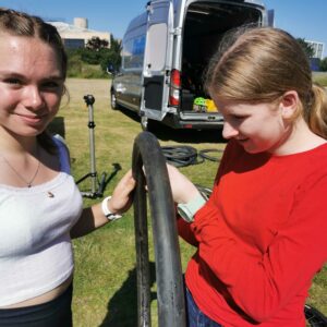 Two girls having a puncture repair lesson