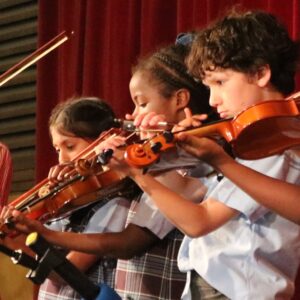 Three children playing violins