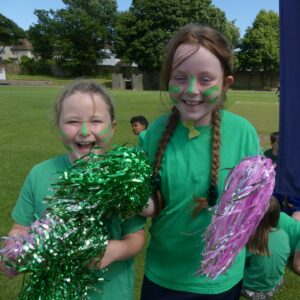 Two girls with pom poms and face paint