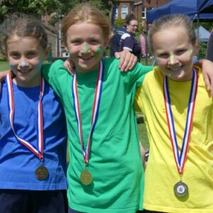 Three girls with medals at Junior School Sports Day