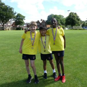 Three boys with medals at Junior School sports day