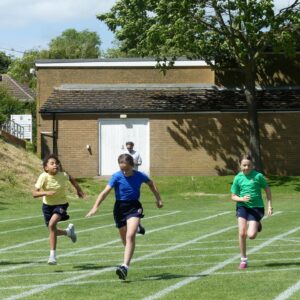 Three girls running at Junior School sports day