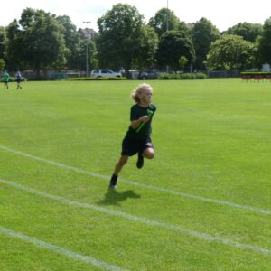 Boy in green running relay race