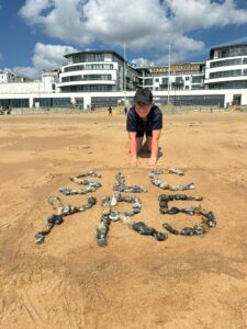 SLC YR5 in stones on beach