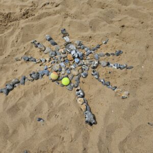 Stone creation with tennis balls on beach