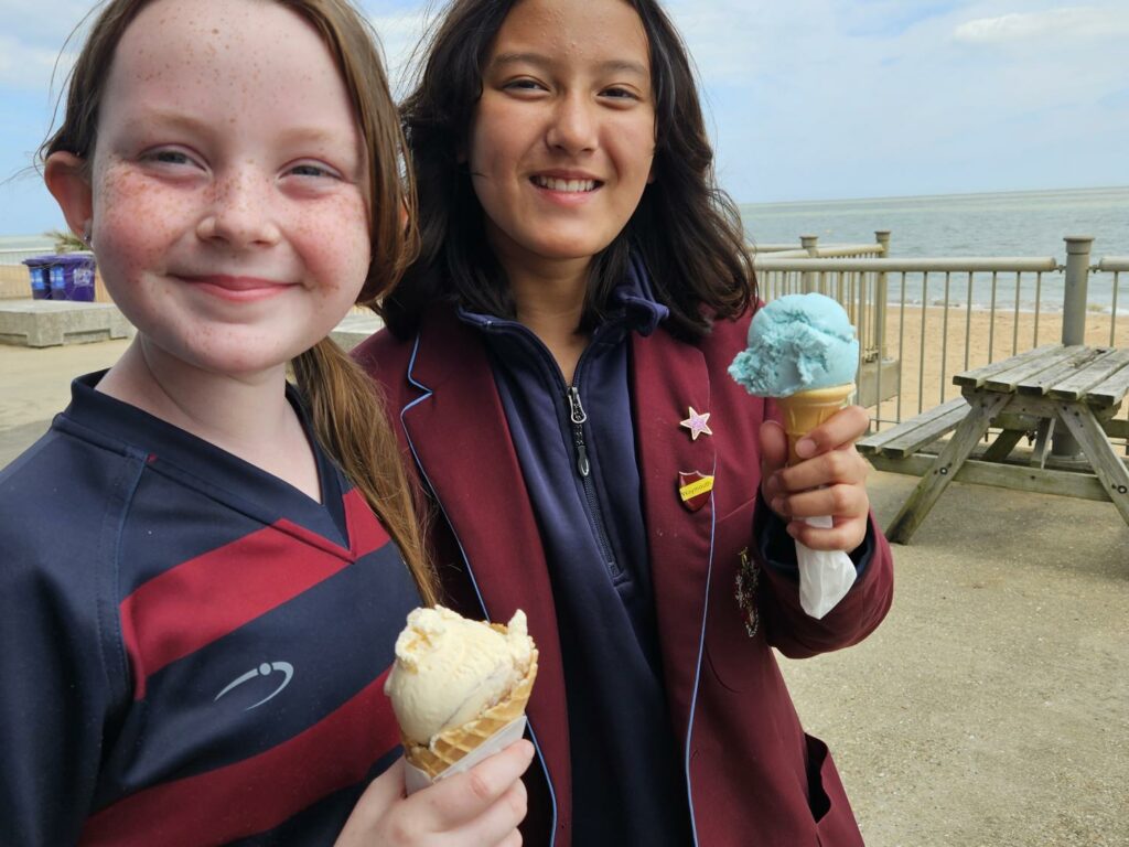 Two girls with ice cream on beach