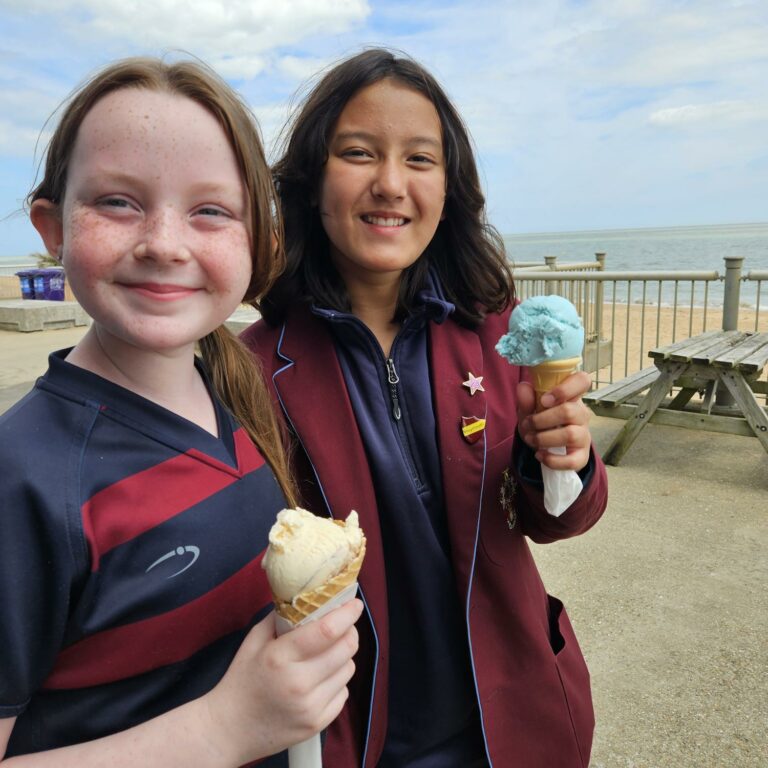Two girls with ice cream on beach