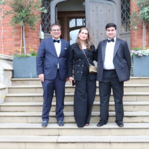 Parents and adult son in black tie on steps
