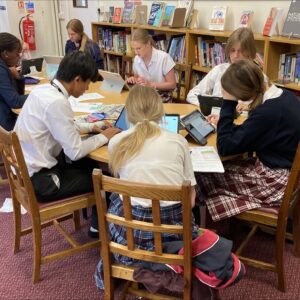 Students in school library working on newspaper