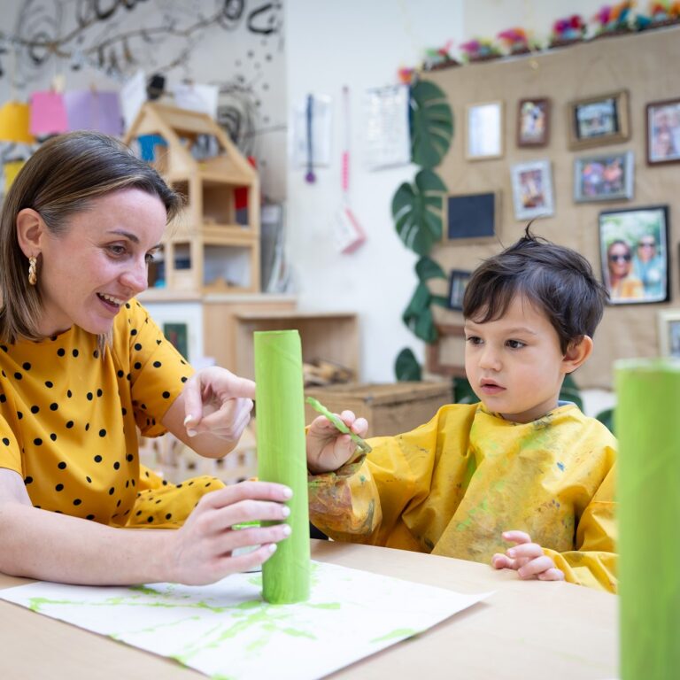 Teacher helping nursery boy