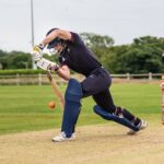 boy hitting cricket ball with cricket bat