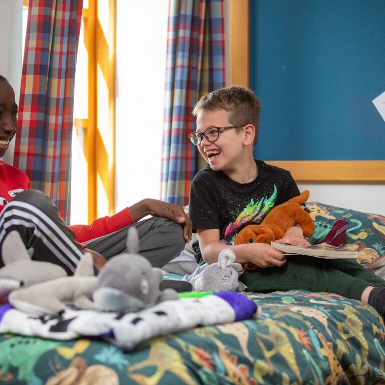 Two boys in boarding bedroom laughing