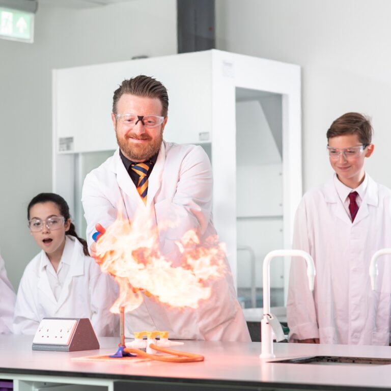 Science teacher with flames doing experiment