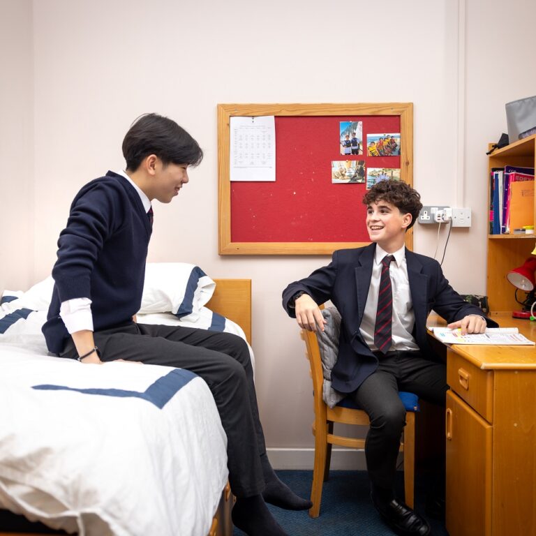 two boys talking in boarding bedroom