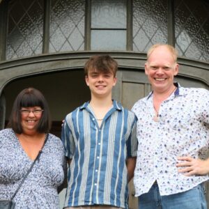 family smiling in front of door