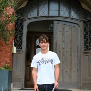 boy smiling in front of door