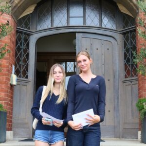 girls smiling in front of door