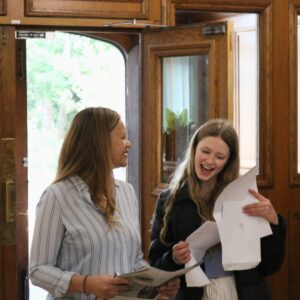 Girl smiling with teacher holding results