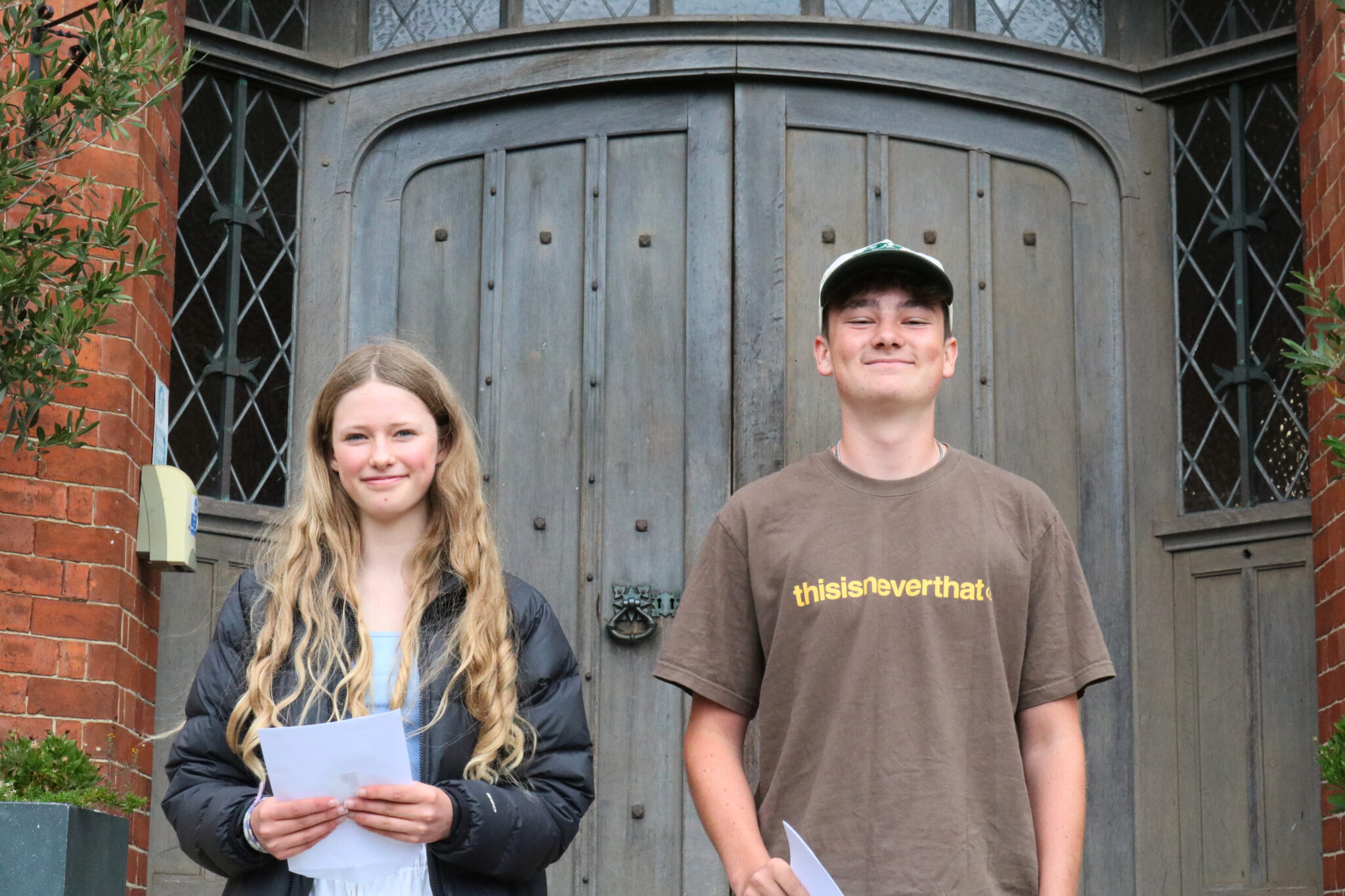 Boy and girl outside door with results