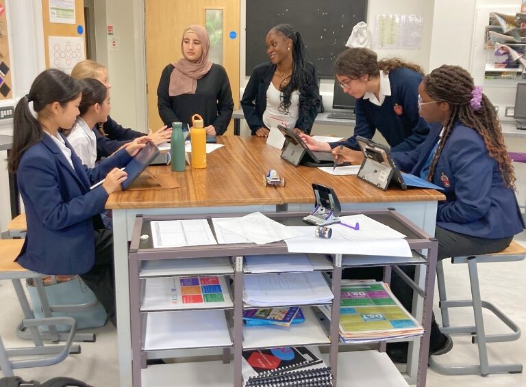 Girls discussing school work around table