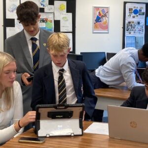 students working on laptops in classroom