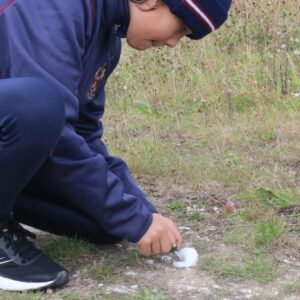 boy lighting cotton wool with flint and steel