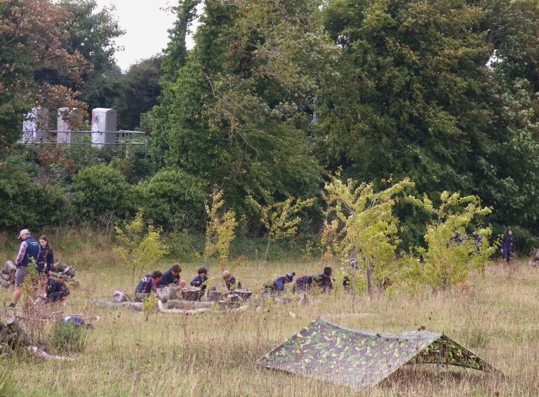 green field with tents and students sat