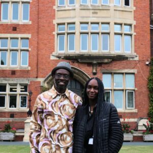 Dad and daughter smiling in front of building