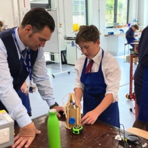 A teacher talking to a boy in workshop