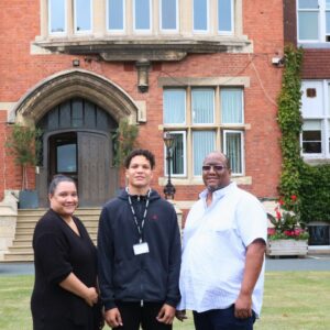 Family smiling in front of school