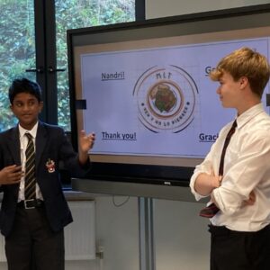 Boys giving presentation on a tv