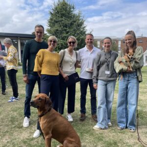 Family smiling with dogs at school event