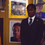 St. Lawrence College student standing proudly beside his photography